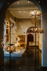 Historical jewelry pieces elegantly displayed in a museum setting, showcasing intricate designs.